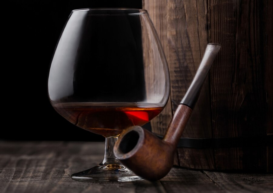 bicchiere-di-cognac-brandy-drink-e-pipa-vintage-accanto-alla-botte-di-legno_157173-1707